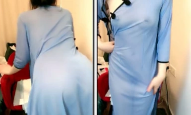 หญิงสาวที่สง่างามสวมชุดกี่เพ้าโปร่งแสง และมองเห็นหัวนมของเธอได้จางๆ และนิ้วของเธอก็กดรูสีชมพูของเธอไว้